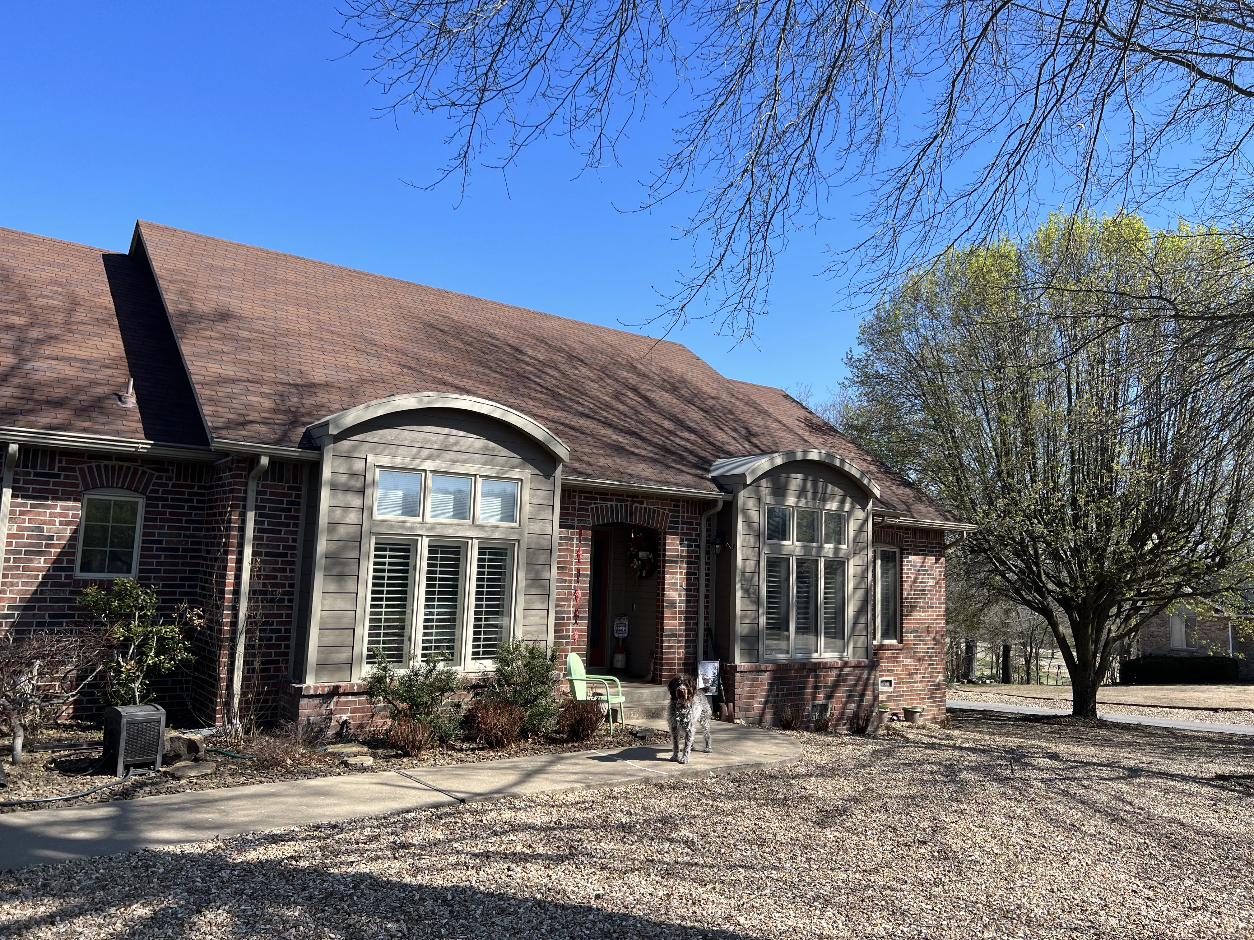Brick home addition with two arched entryways, matching brick veneer, and new windows