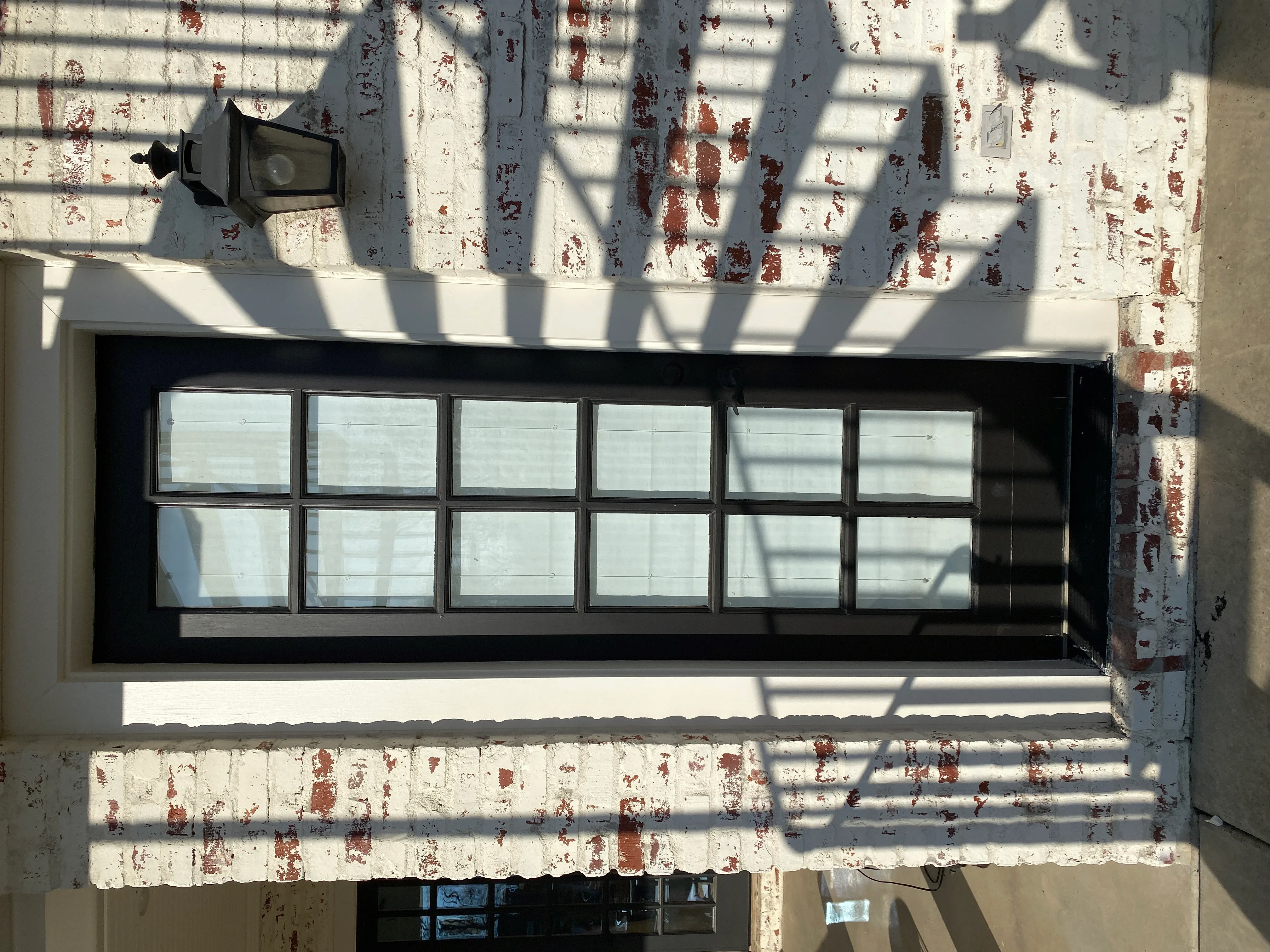 Black aluminum storefront window with 12 clear glass panes installed in brick facade