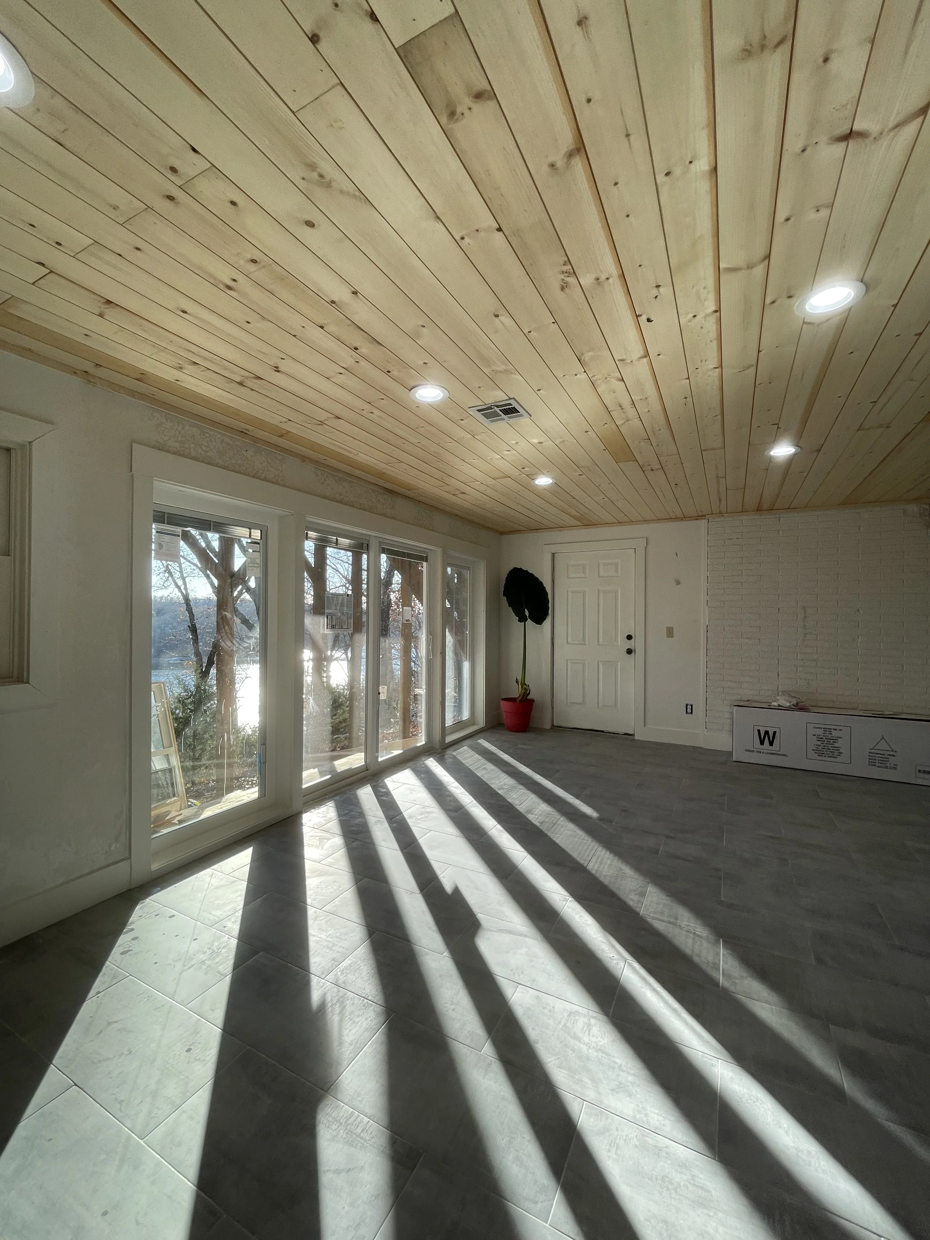 Sunroom with vaulted wood plank ceiling, recessed lights, and multi-panel glass doors