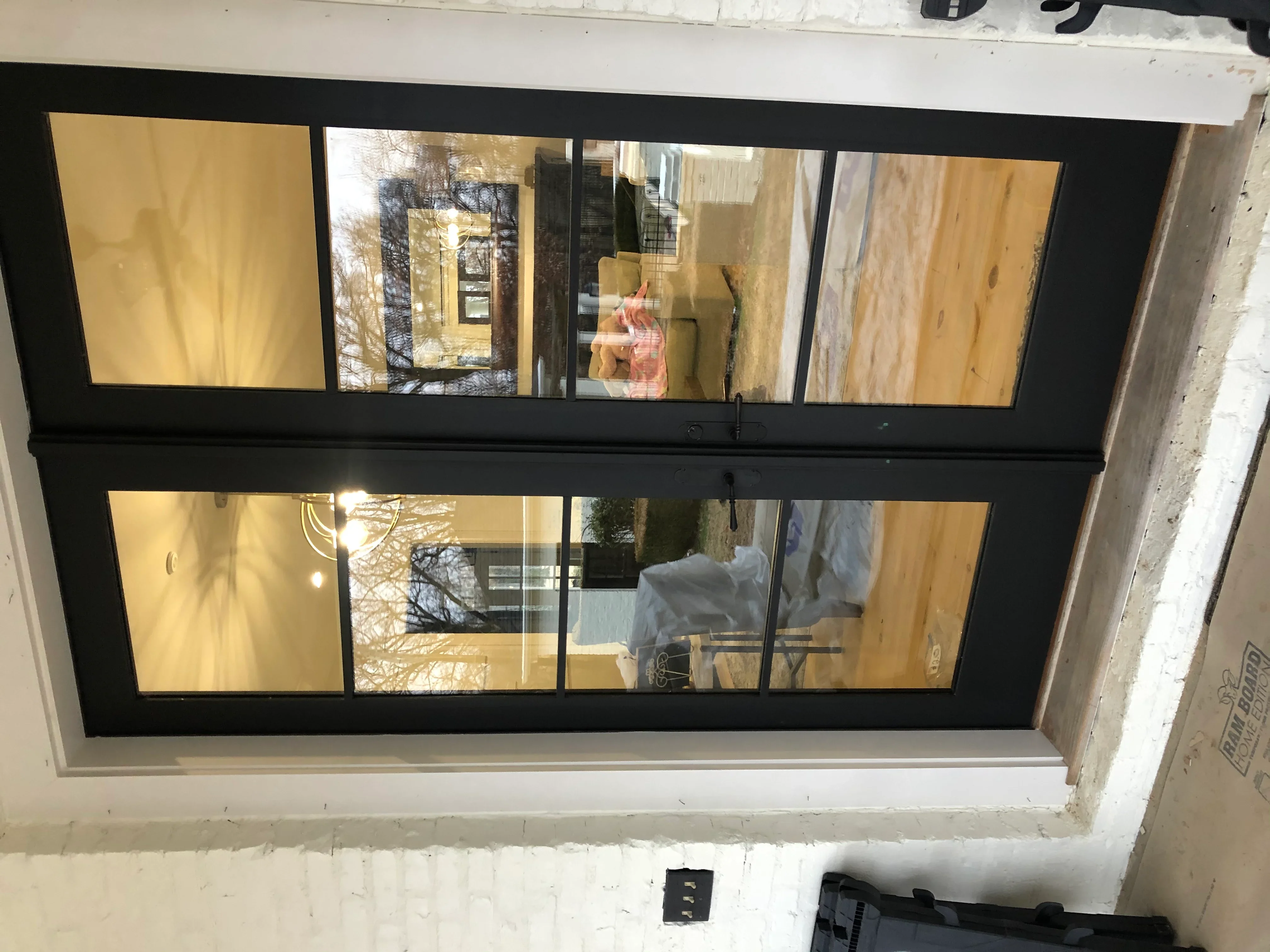 Black-framed commercial window with eight glass panes installed in storefront opening