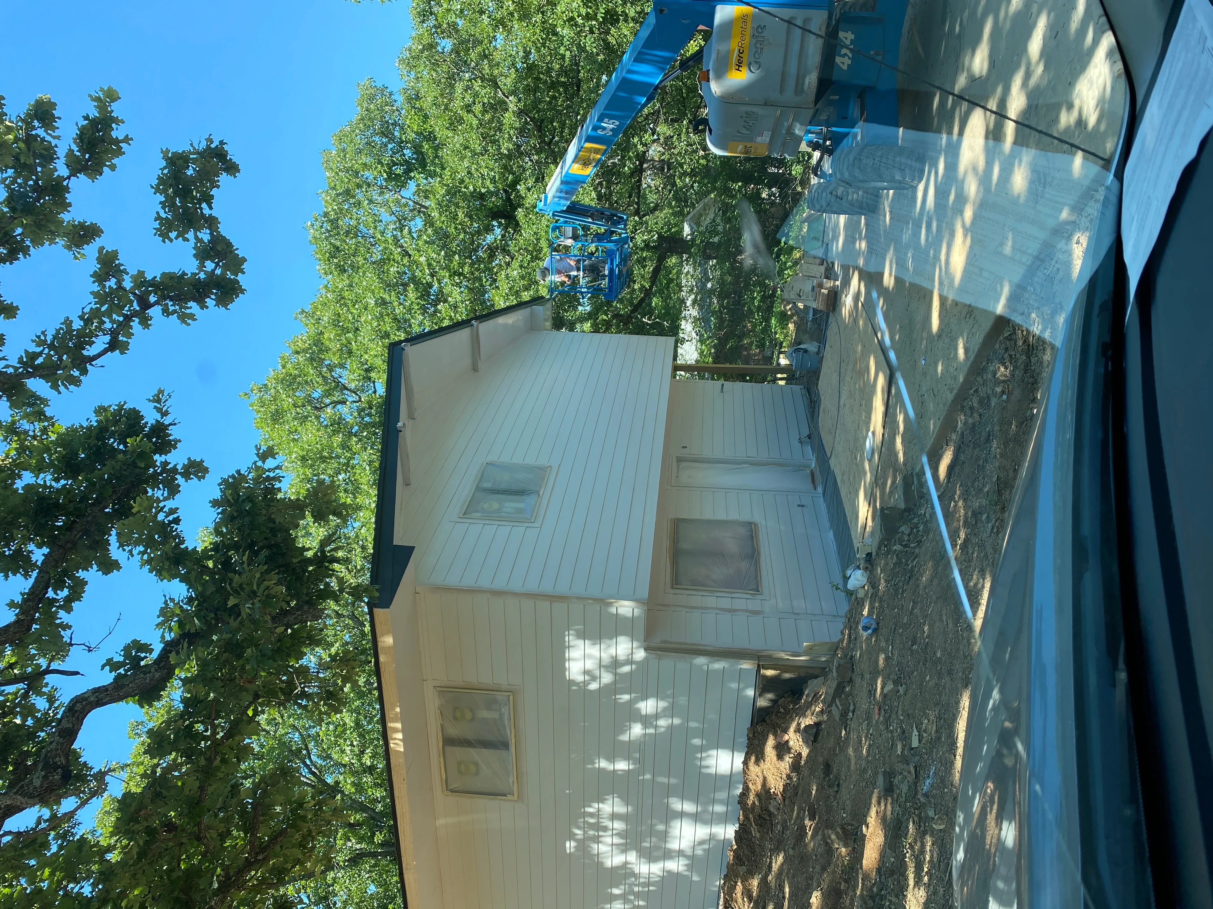 Standing seam metal roof with skylights and vertical siding on residential home