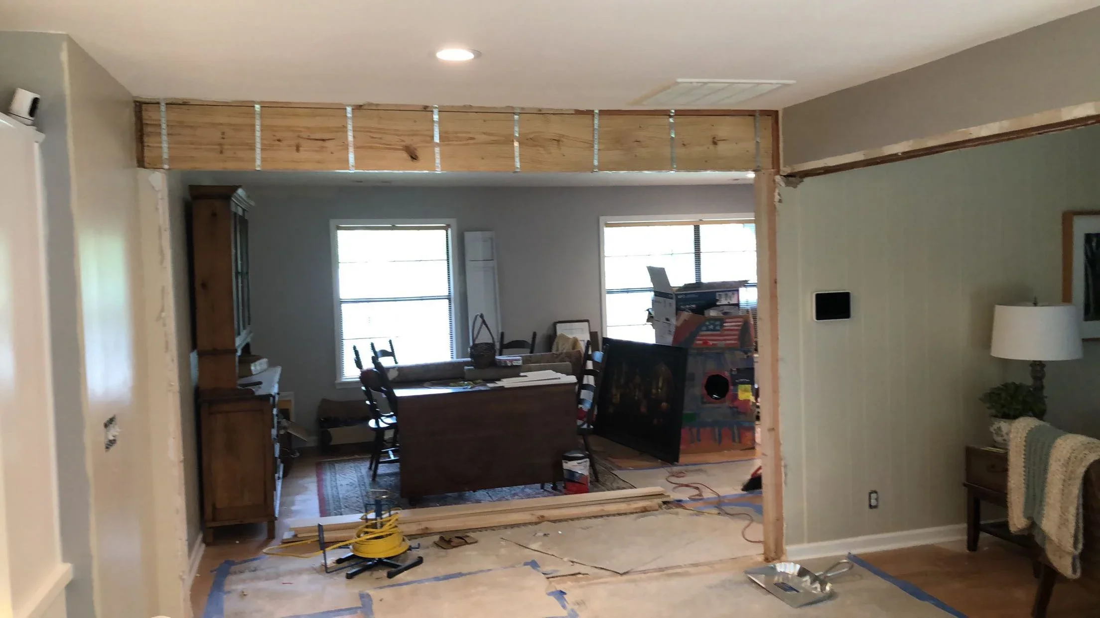 Open concept renovation with removed wall, wood framing, drywall, and recessed lighting installation
